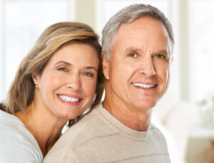 an older couple smiling and showing off their teeth