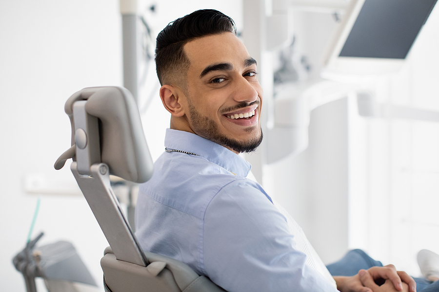 Dental Clinic Patient. Portrait Of Smiling Arab Male Posing In D